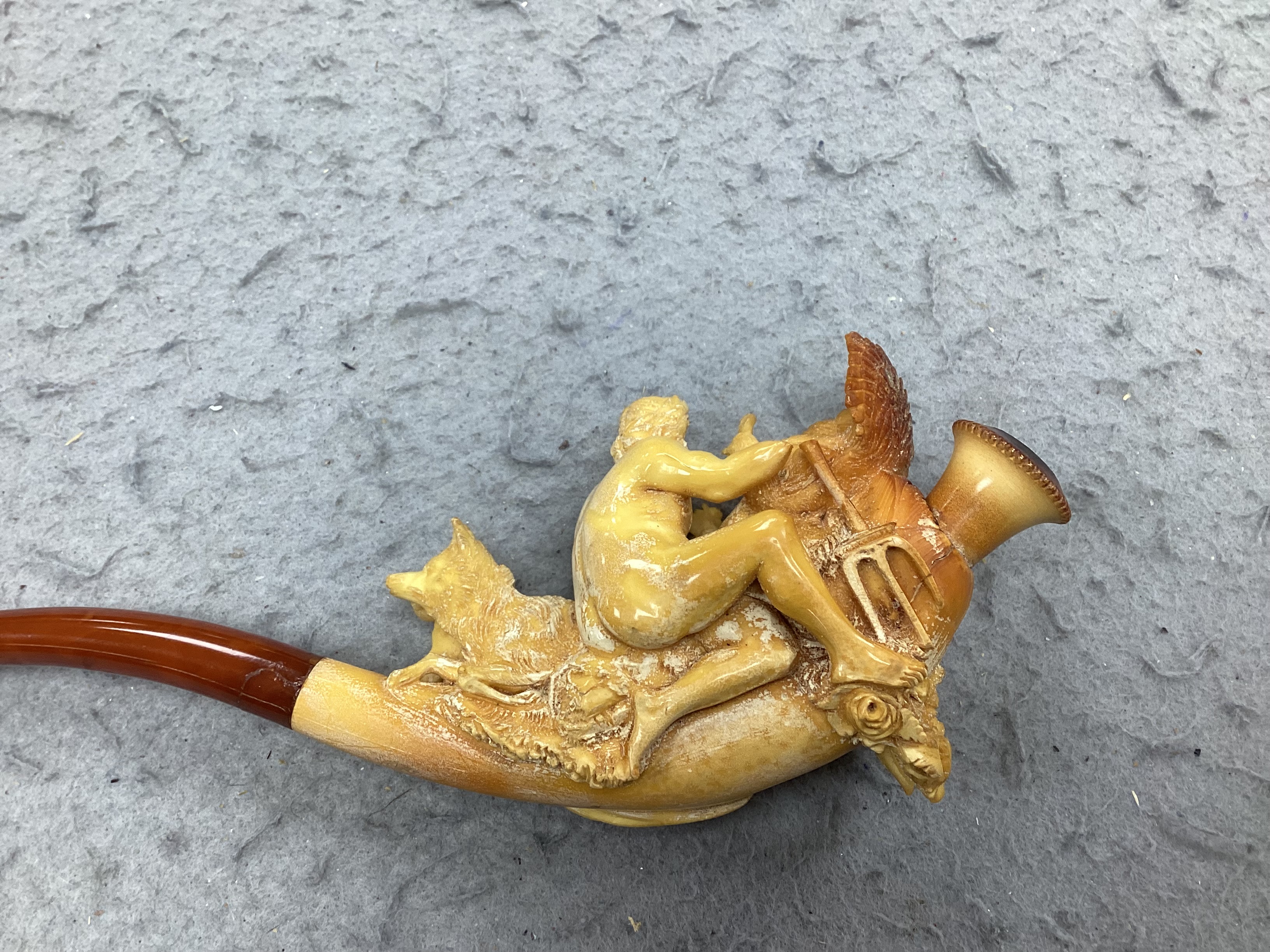 A cased ornate Meerschaum pipe, early 20th century, intricately carved with the figures of Mars and Rhea Silvia with Romulus and Remus and the wolf on the bowl, 18cm long